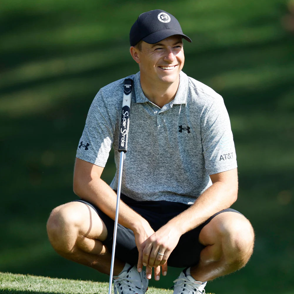 Golf player squatting on a golf course holding a club