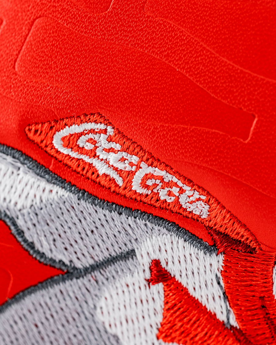 White scarf lettering and subtle bottle outlines on a red textured panel