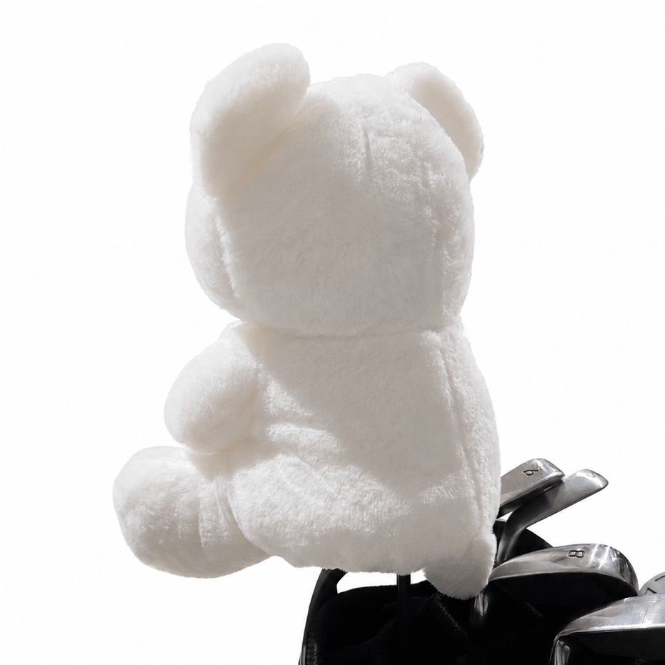 White teddy bear in a golf club head cover on a white background