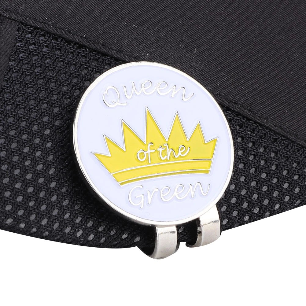 Golf ball marker clip with yellow crown and 'Queen of the Green' text attached to black mesh visor