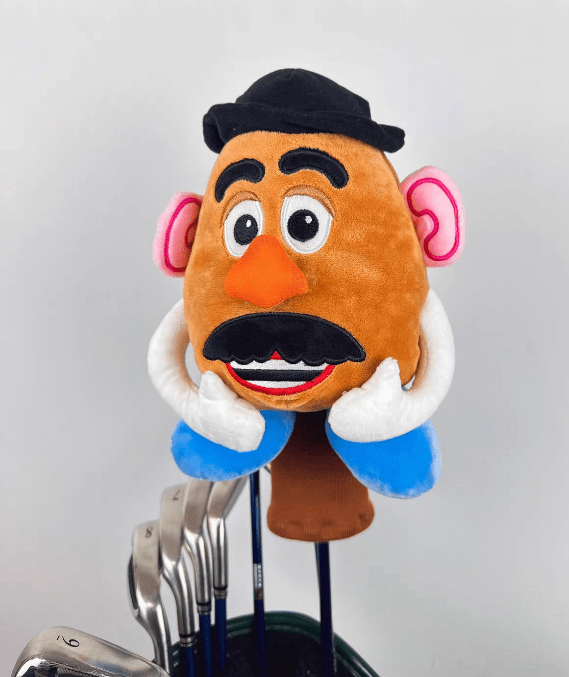 Plush toy resembling a character with a mustache on a golf club head cover.