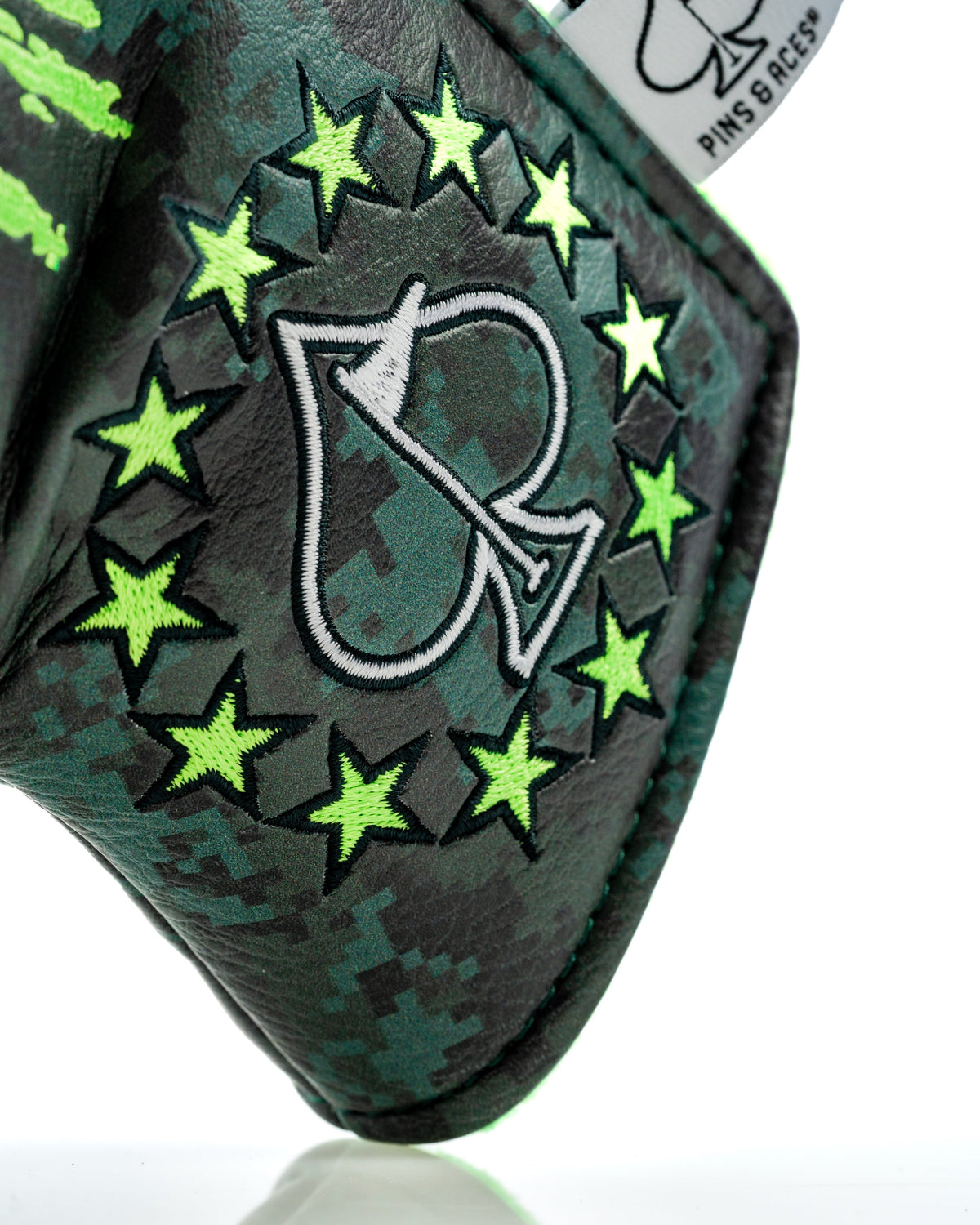 Close-up of embroidered Pins and Aces logo on camouflage headcover
