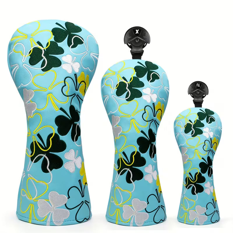 Three golf club heads with floral pattern on a white background