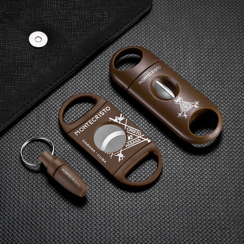 Two brown Montecristo cigar cutters on a textured black surface.