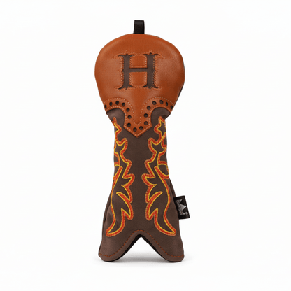 Brown and orange leather golf club head cover with decorative stitching on a white background