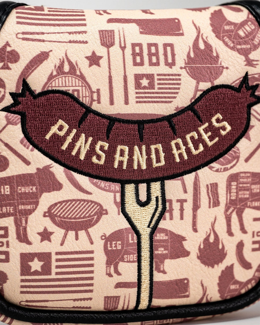 Sausage-on-fork embroidery over cream and burgundy barbecue pattern