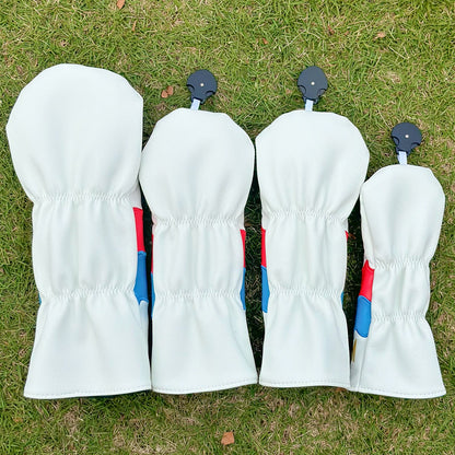 Four white golf club heads with blue and red accents on a grass background