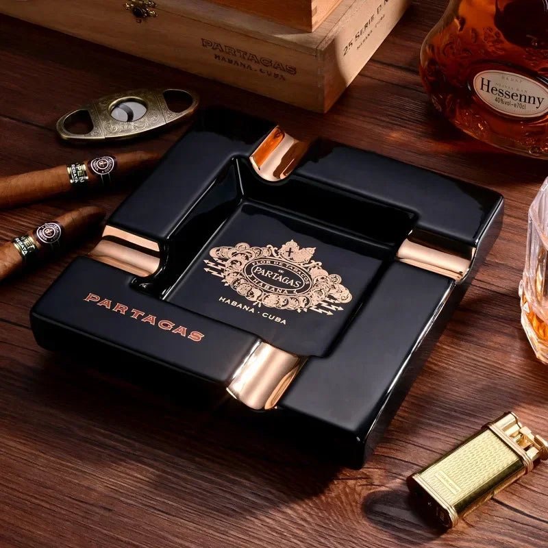 Partagas black-and-gold square Lounge Boss ashtray on a wooden table