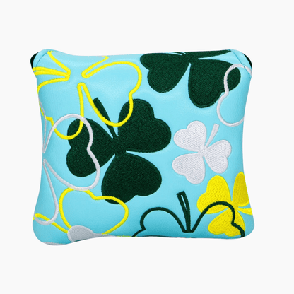 Decorative pillow with clover and leaf patterns on a blue background