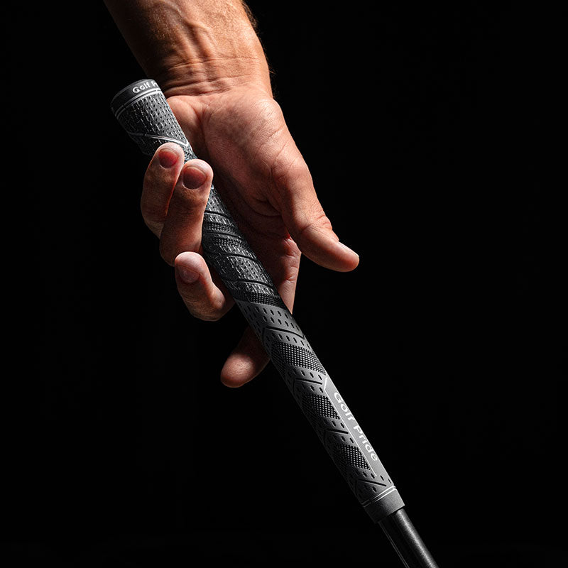 Hand holding Golf Pride MCC Plus4, showing its cord upper section and rubber lower section