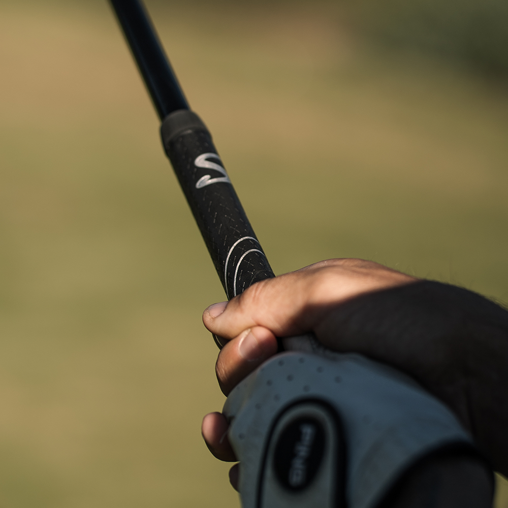 Gloved hand holding a SuperStroke Cross Comfort grip