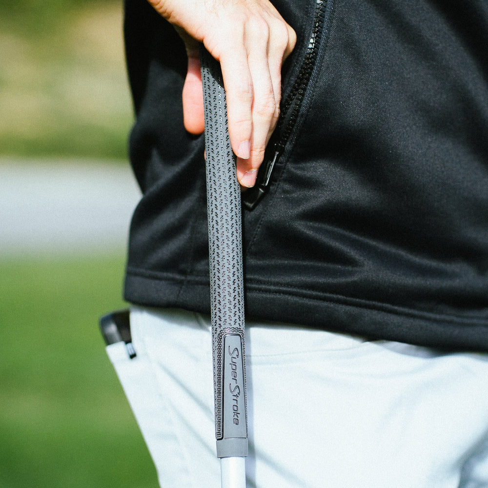 Golfer holding a grey SuperStroke Crossline 2.0 grip on the course