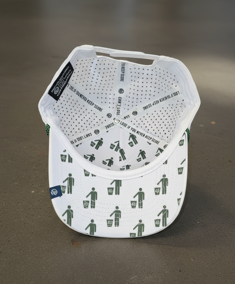 White cap with green graphic design on a brown surface