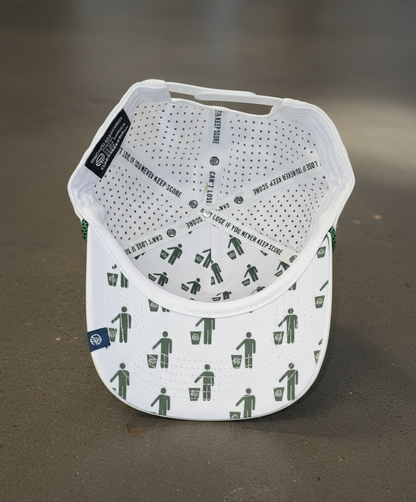 White cap with green graphic design on a brown surface