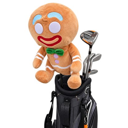 A plush gingerbread character golf club holder or stand with a golf bag and several golf clubs, shown on a plain white studio background.