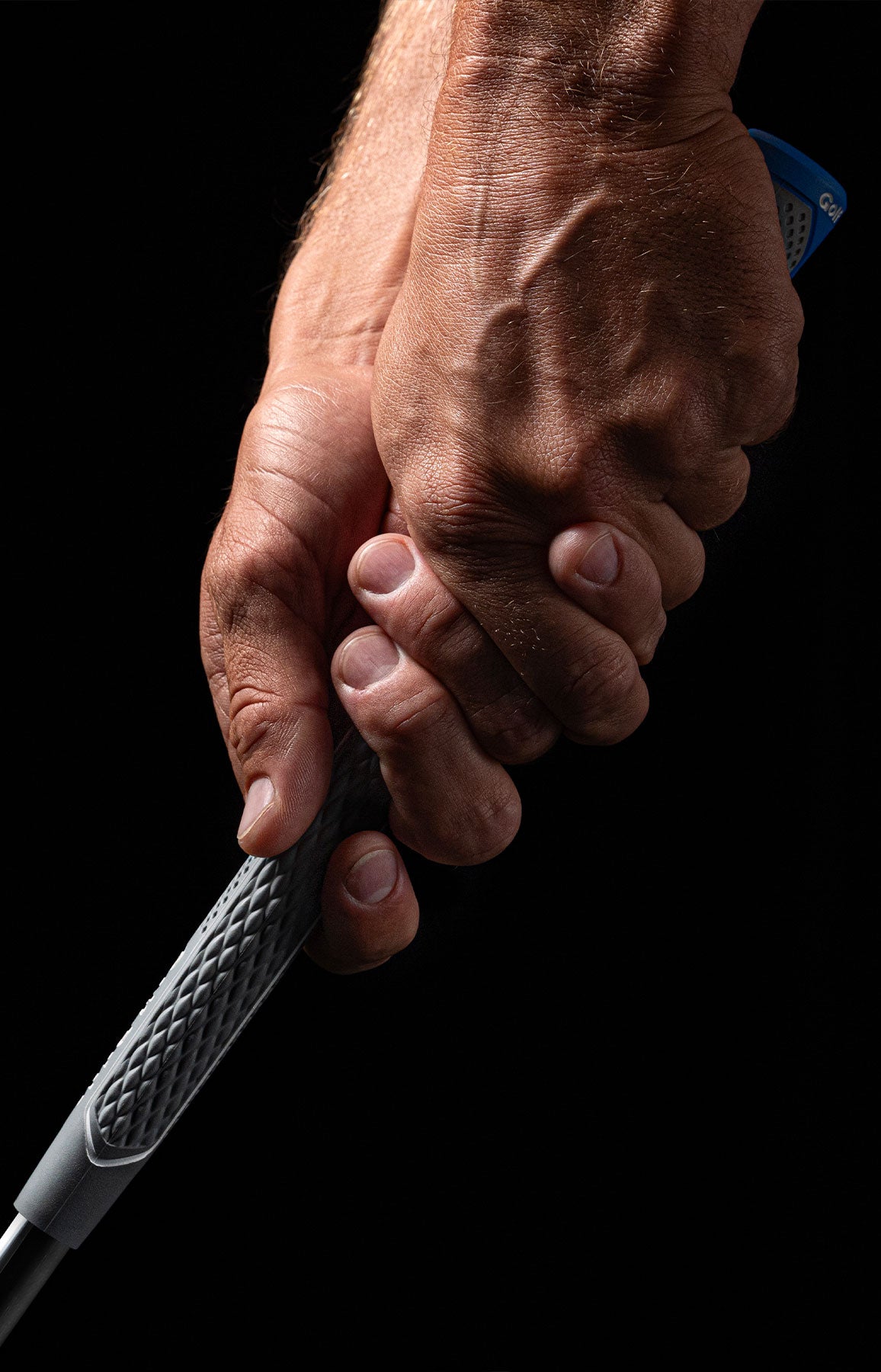 Hands holding a genuine Golf Pride CPX grip, showing its cushioned rubber surface