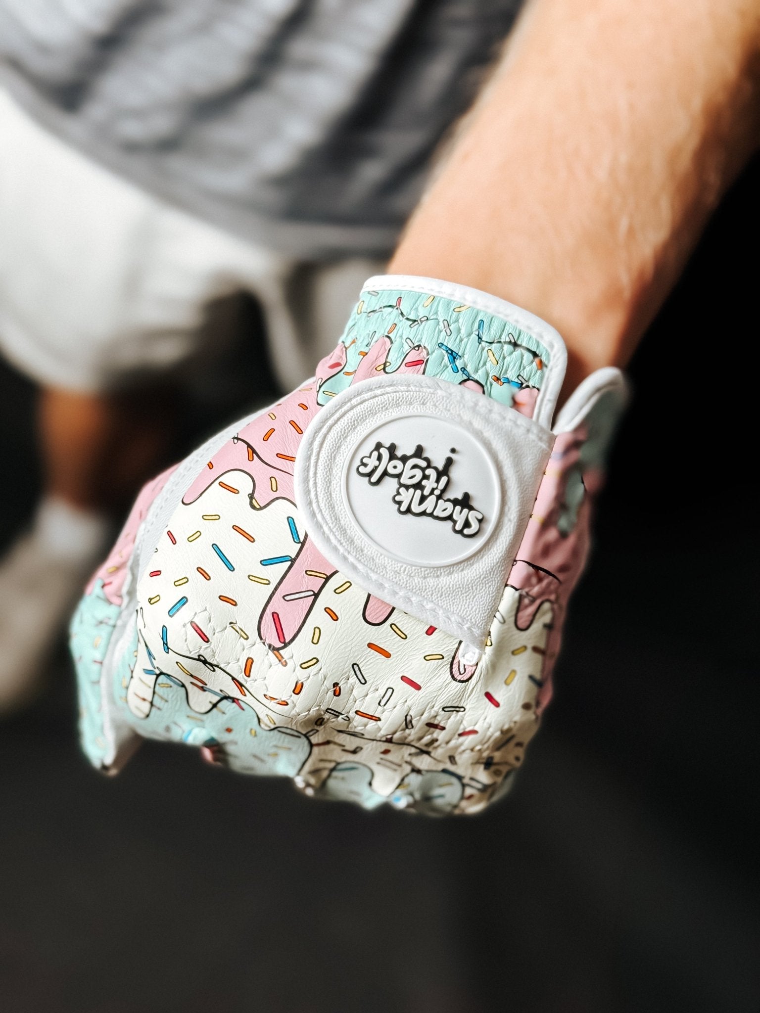 Gloves with colorful donut pattern and brand logo on a dark background