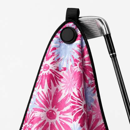 Golf club with a pink floral towel draped over it on a white background