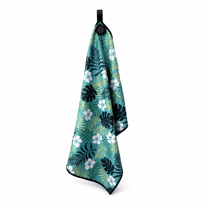 Tropical patterned towel hanging on a hook against a white background