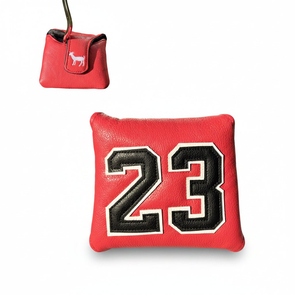 Red golf ball marker with number 23 on grass, red carrying case above