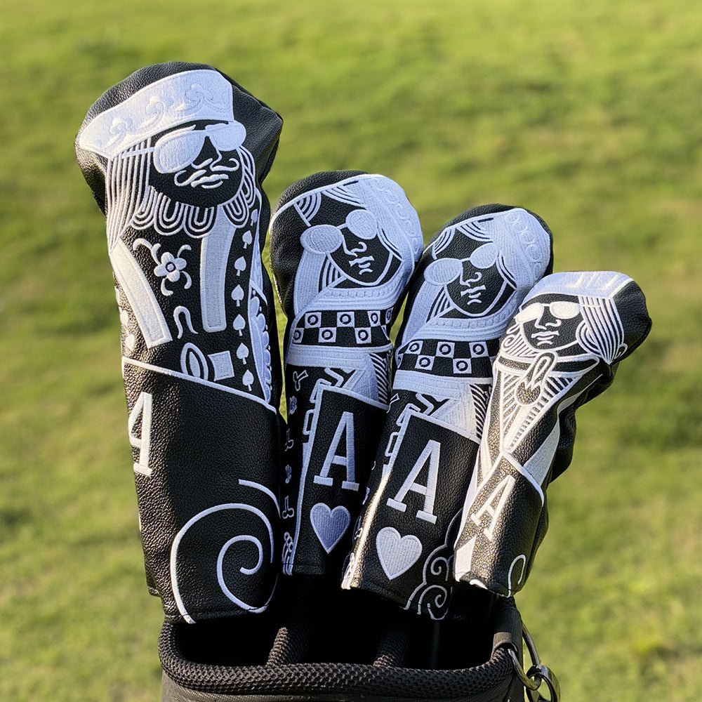 Golf club heads with decorative covers on a grass background
