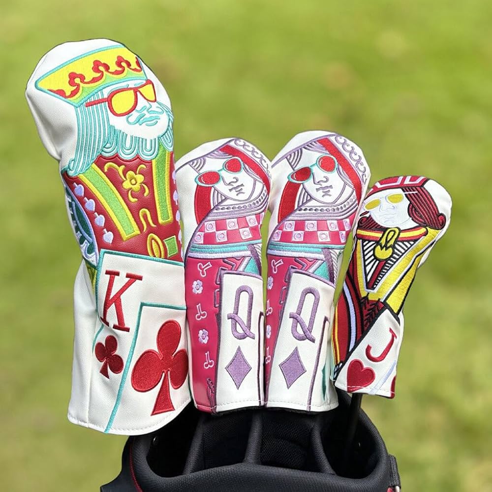 Golf club head covers with playing card designs on a grass background