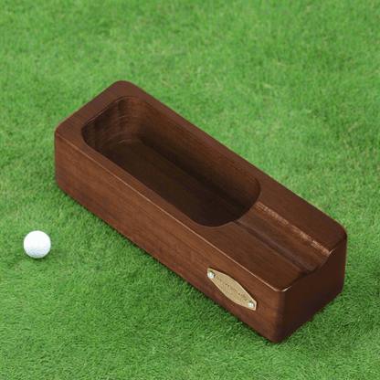 Wooden golf ball retriever on a green grass background