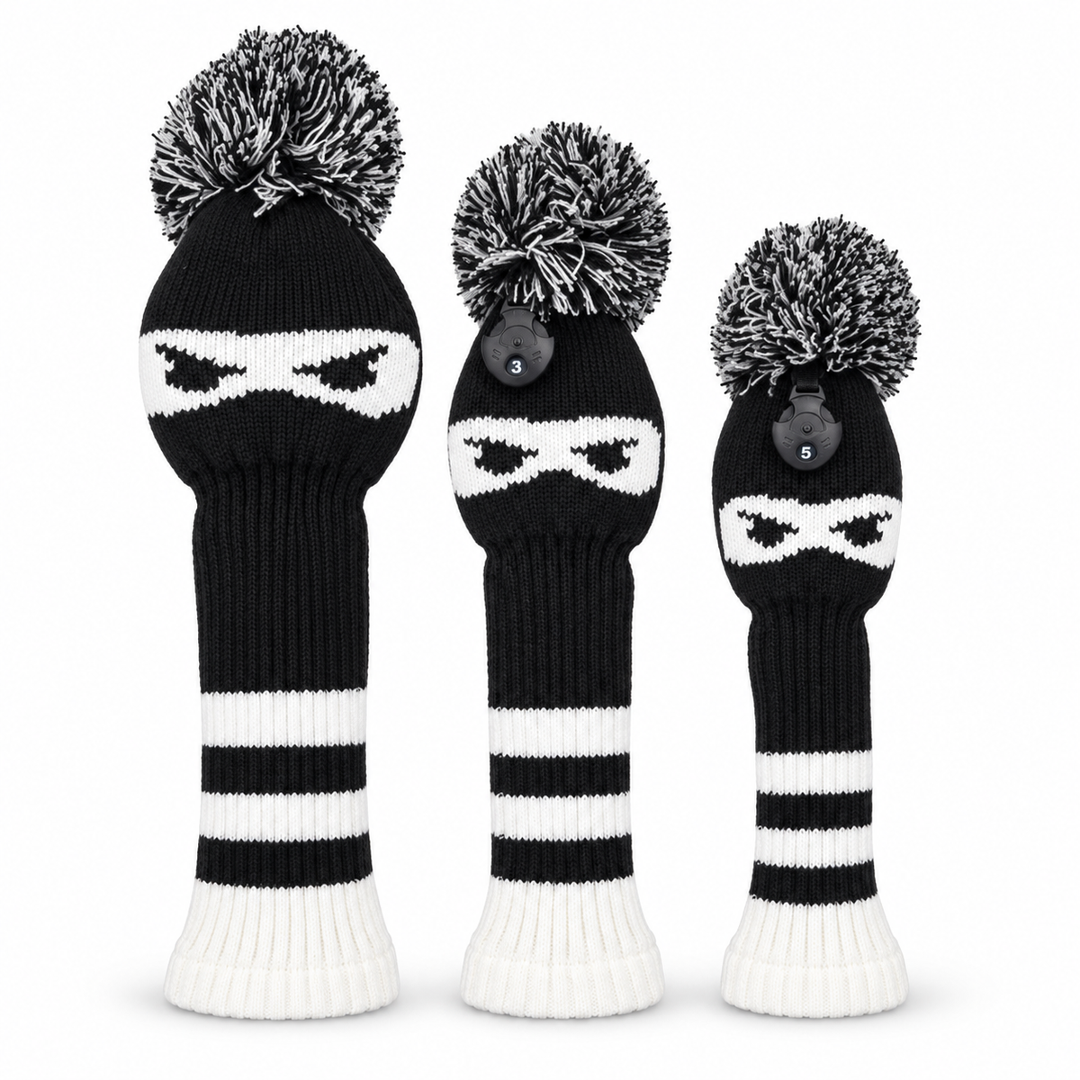 Three black-and-white ninja knit golf headcovers with pom-poms on a white background