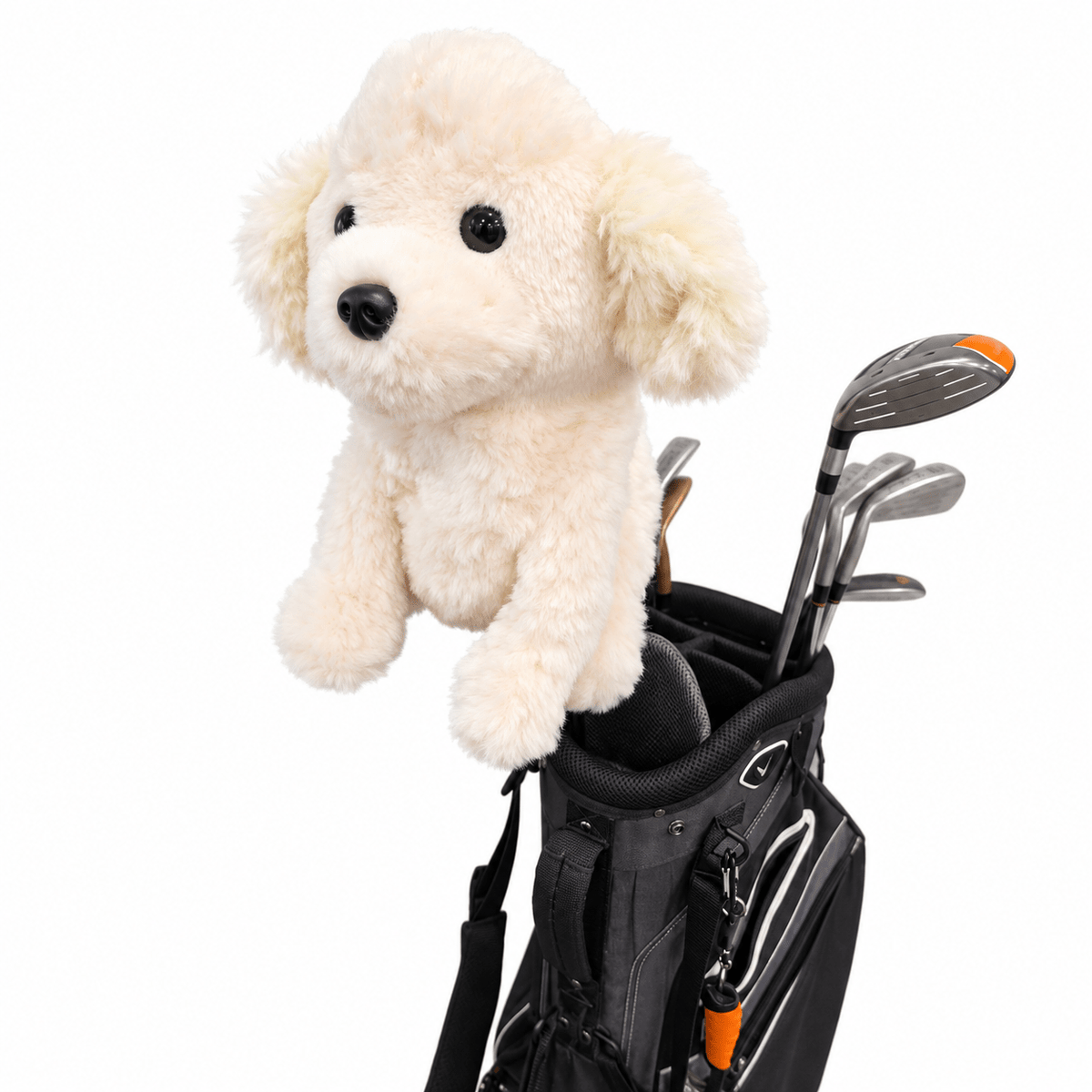A cream-colored plush dog toy with black eyes and nose sits on top of a black golf bag containing golf clubs, isolated on a white background.