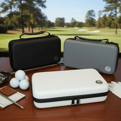 Golf accessories including clubs, balls, and cases on a table with a golf course background.