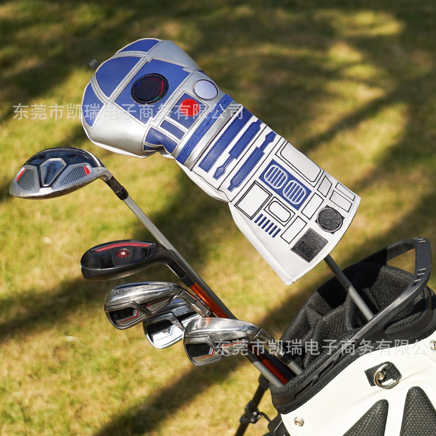 Golf club set with R2-D2 design on the club head cover against a grassy background
