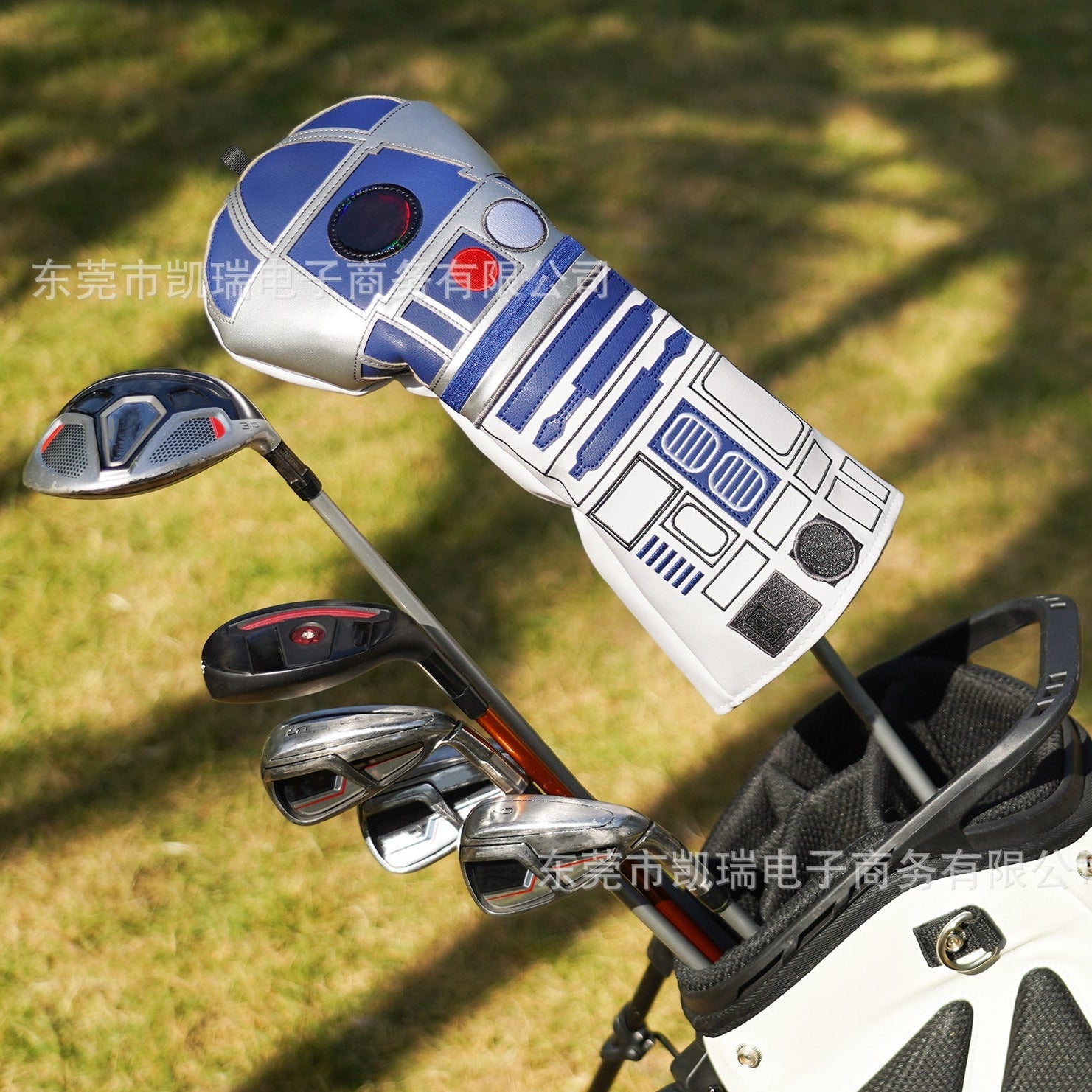 Golf club set with R2-D2 design on the club head cover against a grassy background
