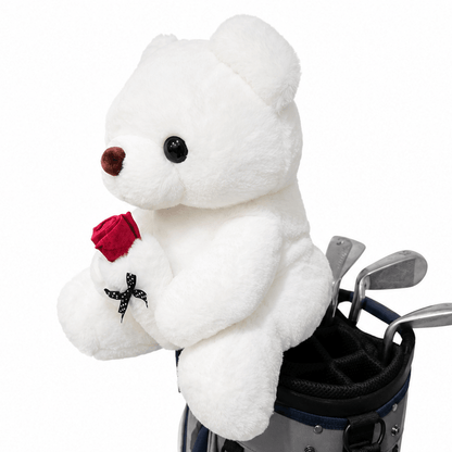 White teddy bear holding a red rose next to a golf bag on a white background