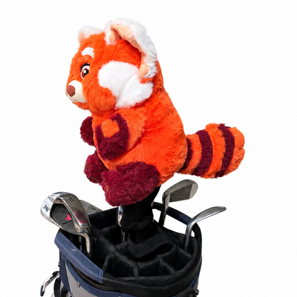 Plush toy red panda in a golf bag with golf clubs on a white background