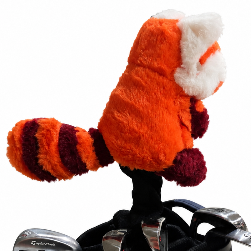 Plush red panda headcover on top of a golf club set with a white background