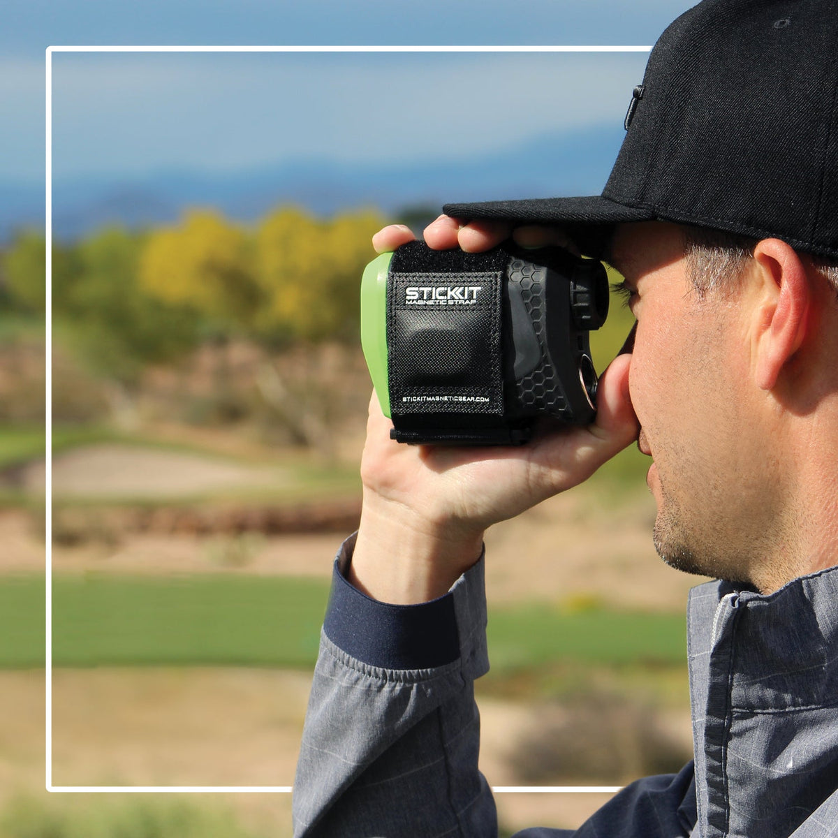 Golfer using a rangefinder fitted with the black STICKIT Gen3 magnetic strap; rangefinder not included