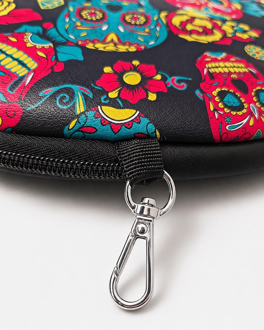 Colorful skull and floral patterned pouch with a metal clasp on a white background