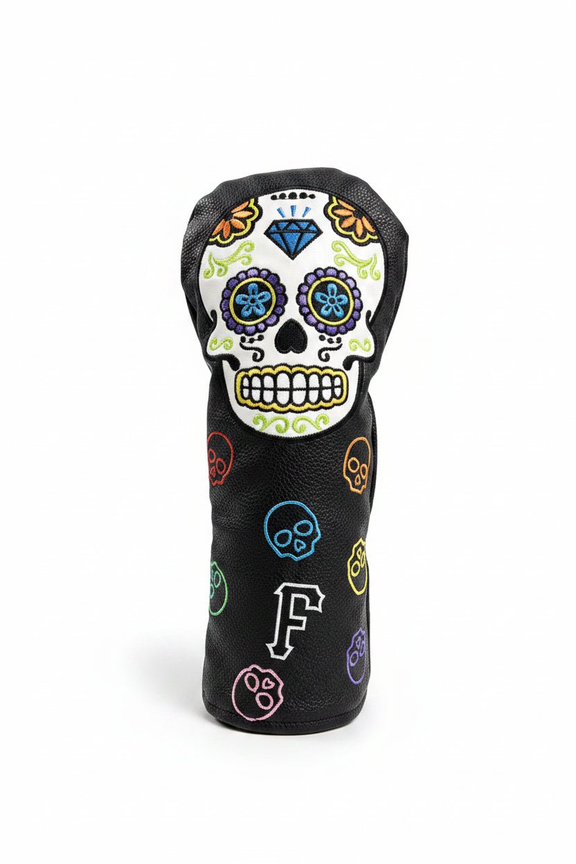 Golf club head cover with skull design on grass
