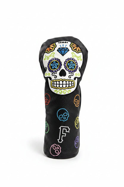 Golf club head cover with skull design on grass