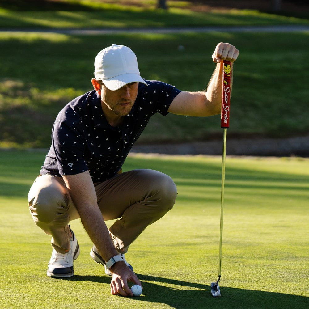 Man on a golf course preparing to putt with a putter