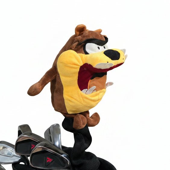 Plush toy resembling a bird on a golf bag with golf clubs attached, inside a vehicle.