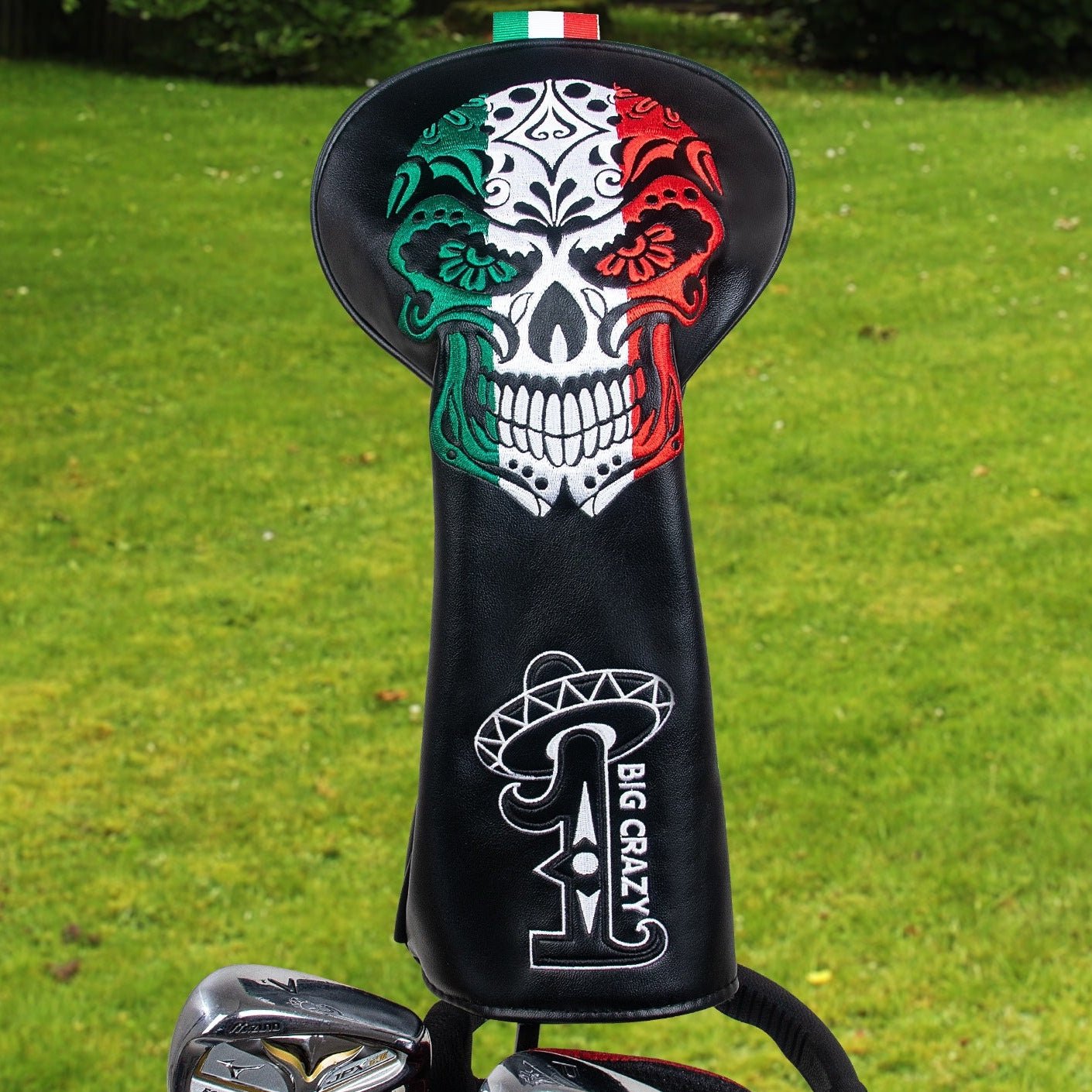 Golf club head cover with skull design and 'BIG CRAZY' branding on a grass background