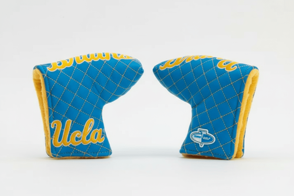 Two blue and yellow UCLA golf club covers on a white background